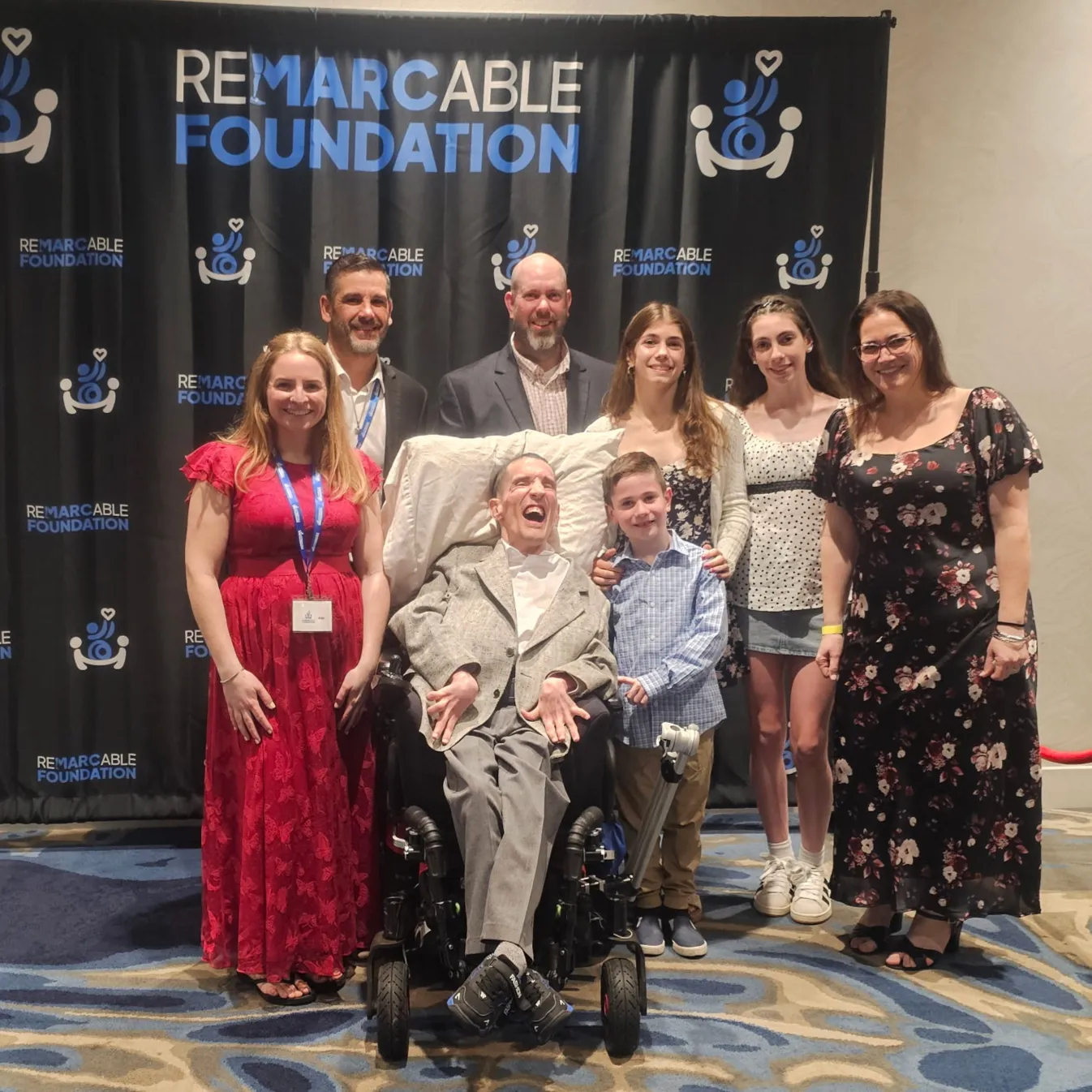 Wheelchair users and supporters at an Abilities Expo booth with The ReM.A.R.C.able Foundation